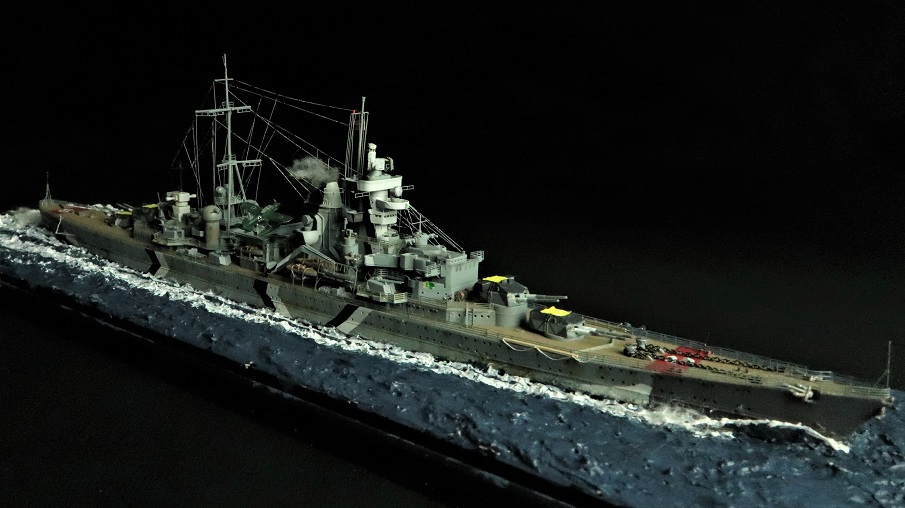1/700 scale diorama of the German heavy cruiser Prinz Eugen underway at sea, photographed against a black background with realistic wake effects.