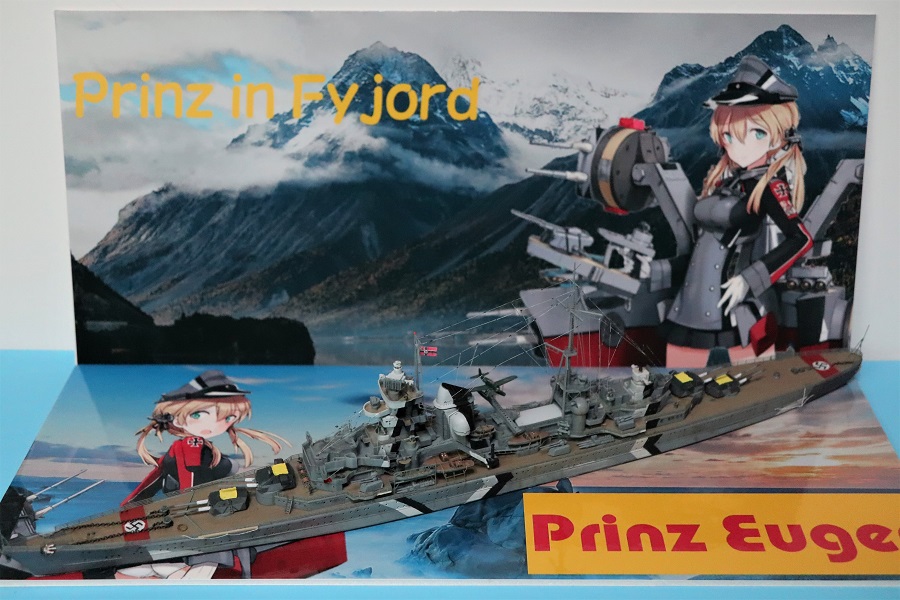 Diorama-style display of the 1/700 Prinz Eugen model with character-themed background artwork inspired by naval games.
