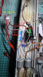 Top-down view inside a 1/150 Yukikaze RC hull showing twin motors, receiver, servo, and wiring layout during test setup