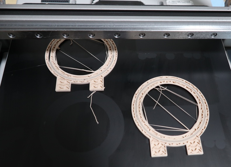 Matte PLA print showing stringing between circular display stand parts