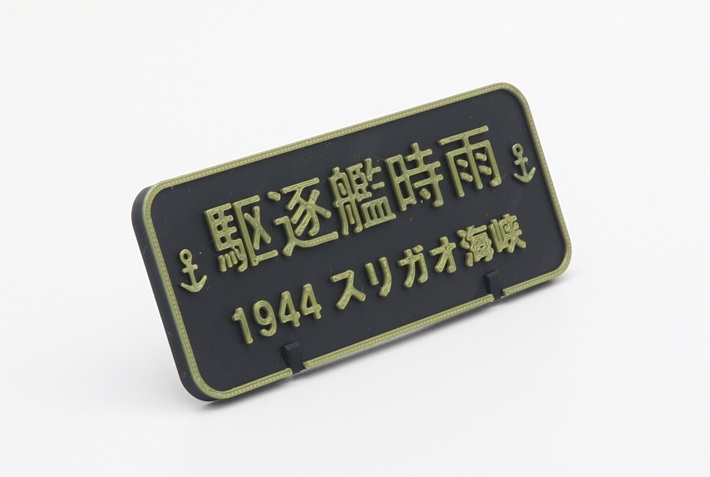 Angled view of a black and gold 3D printed nameplate for IJN destroyer Shigure 1944 Surigao Strait