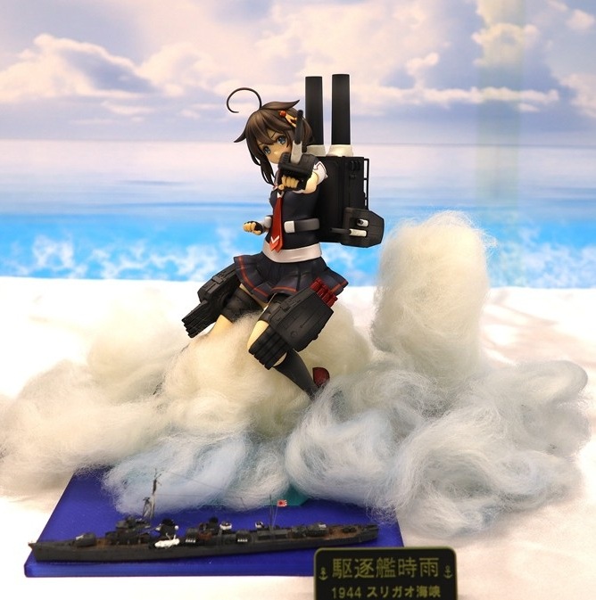 Kantai Collection Shigure figure posed above a 1/700 destroyer diorama with dramatic smoke effects at Okahobi 2026